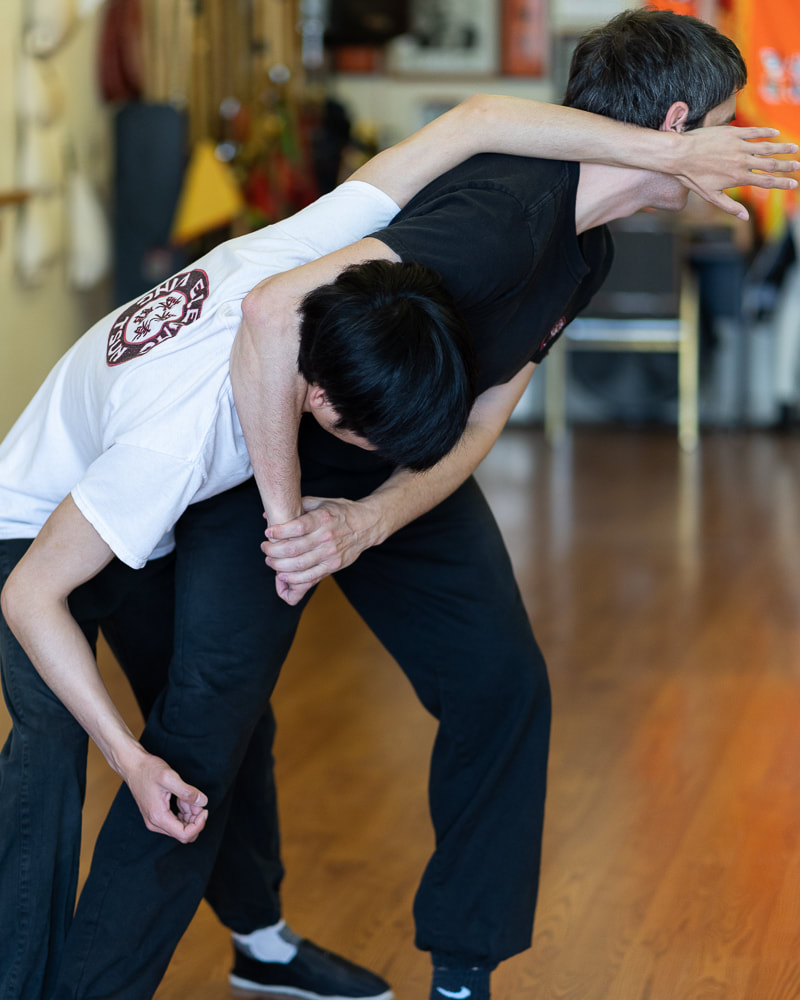 Sifu Matyas Tamas teaching a student how to defend a head lock using Wing Chun kung fu techniques